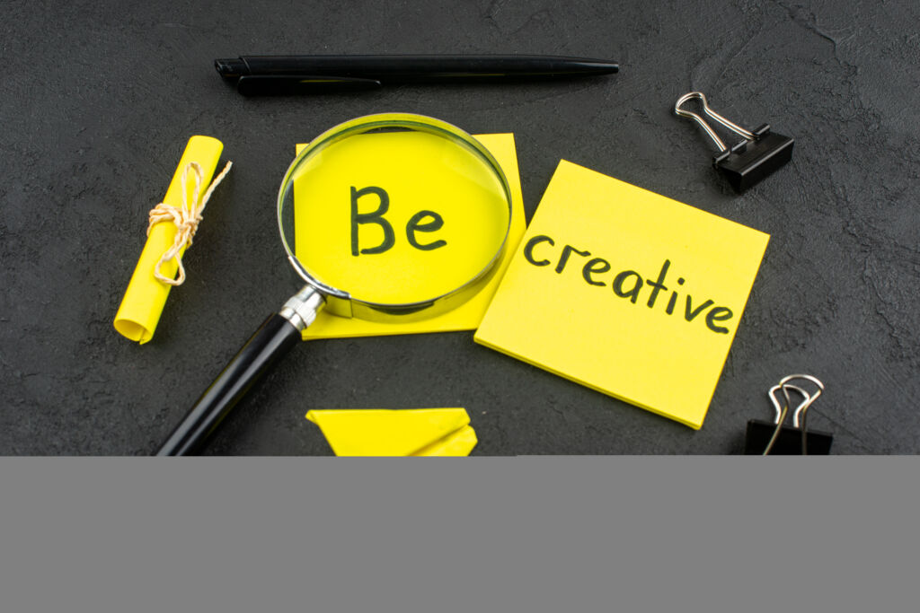 Yellow sticky note with Be Creative message inspiring innovative digital marketing campaigns.